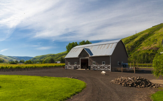 The Mongata Estate Winery barn with rolling green hills in the background